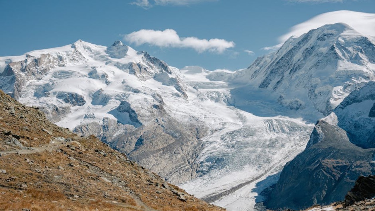Two professional esports coaches intensely watching gameplay footage on multiple screens, one with CS2 and the other with Valorant.
