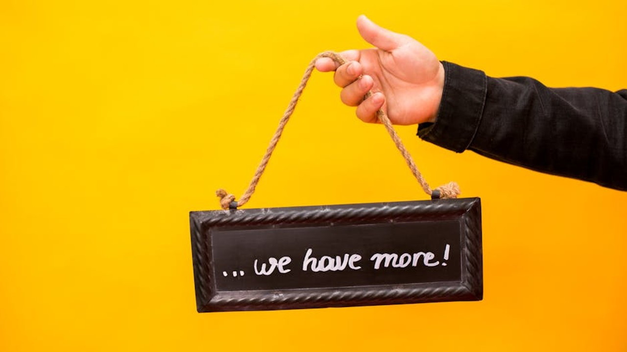 A Counter-Strike 2 coach pointing at a specific utility throw trajectory on a monitor during a demo review session.